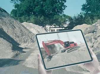 tablet mit bagger auf einer baustelle