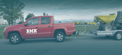 Roter Pickup mit Wacker Neuson Dumper auf dem Anhänger